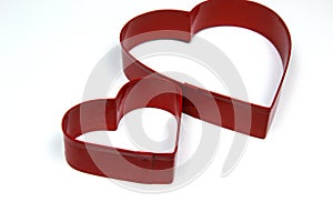 Two Red Metal Heart Shaped cookie Cutter on White backg