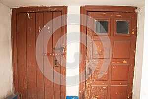 Two red old doors in the entrance of a residential building in Ukraine, the building and the interior