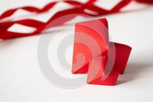 Two red origami hearts and satin ribbons on white background in front view with copy space. Template Valentine`s day