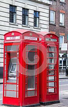 Two red phone booths on the street of London