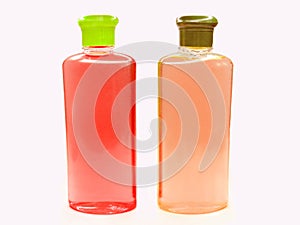 Two red and pink fruit shampoo bottles