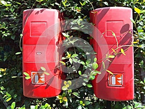 Two red plastic boxes containing fire extinguishers