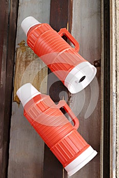 Two red plastic thermos bottles