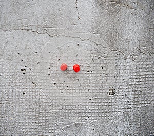 Two Red Push Pins on a wall