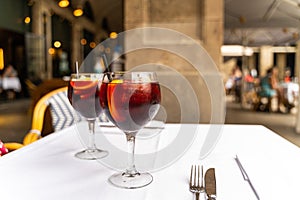 Two red sangria glasses on white tablecloth in restaurant