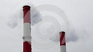 Two red smoking pipes on the background of Cloudy sky