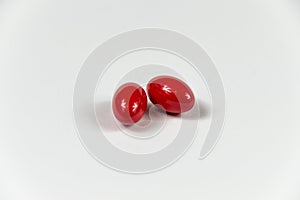 Two red soft gelatine capsules.