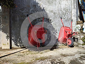 Two red sorong carts, or commonly called angkong, were leaning against the wall.