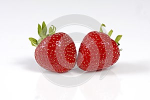 Two red strawberrys on white background.