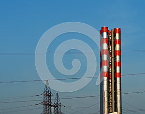 Two red stripy industrial chimneys background