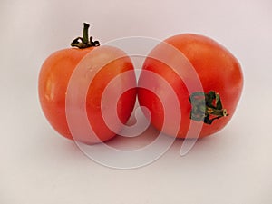 Two red tomatoes isolated on white background