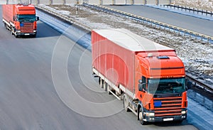 Two red tractor trailer trucks caravan convoy line