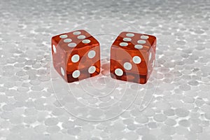 Two red transparent dice on a foam board.