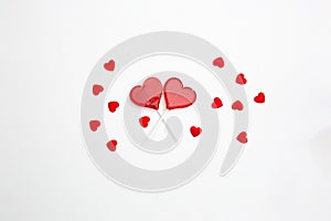 two red Valentine's day heart shape lollipop candy on empty white paper background. Love Concept. top view. Minimalism