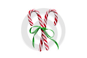 Two red and white Christmas candy canes with green Ribbon bow, isolated on white background