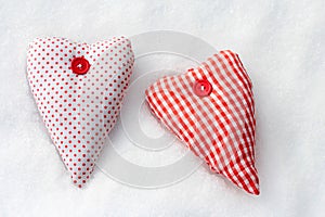 Two red-white fabric hearts in the snow