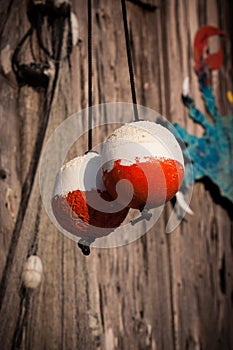 Two red and white fishing markers, buoys, hang to dry