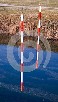 Two red and white stakes for canoe