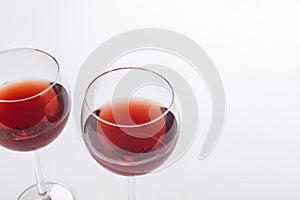 Two red wine glass on white background.