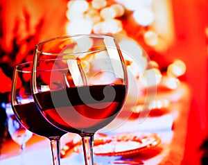 Two red wine glasses against restaurant table background