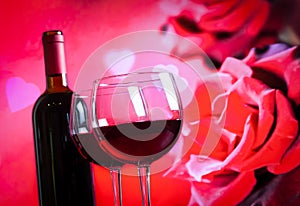 Two red wine glasses on blur red roses background