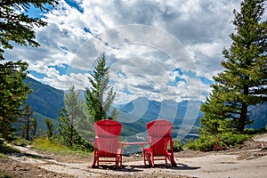 Two red wooden chairs on Tunnel Moutain with a view on Banff, Rocky Mountains, Alberta Canada