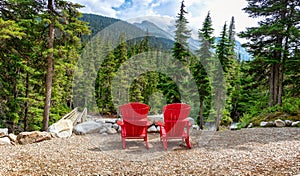 Two red wooden chairs with a view on the mountains in Glacier National park, Rocky Mountains, Bristish Columbia Canada