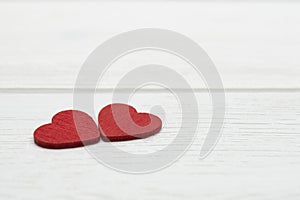 Two red wooden hearts on white wooden background. Valentine`s day or Love concept.