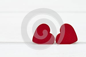 Two red wooden hearts on white wooden background. Valentine`s day or Love concept.