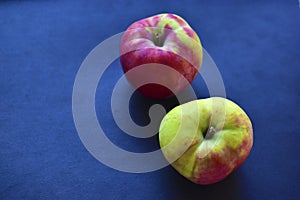 Two red and yellow ripe apples on a black background