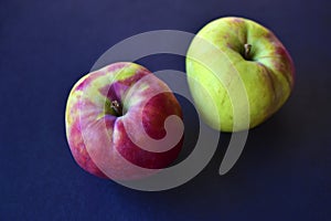 Two red and yellow ripe apples on a black background