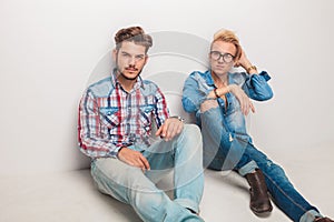 Two relaxed fashion men sitting on the floor