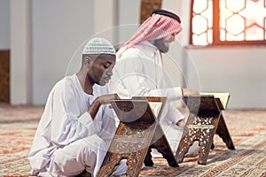 Two religious muslim man praying together inside the mosque