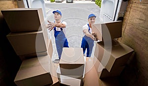 Two removal company workers unloading boxes from minibus