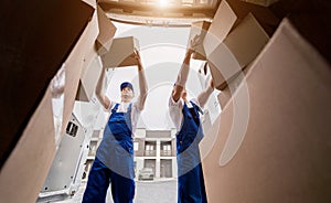 Two removal company workers unloading boxes from minibus