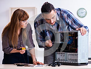 Two repairmen repairing desktop computer