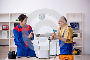 Two male repairmen working at workshop