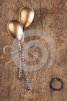 Two retro desset spoons tied on old wooden table