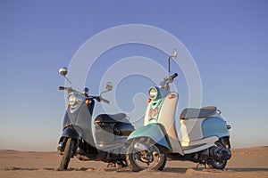 Two Retro scooters at sunset in the golden sand of the Namib Desert