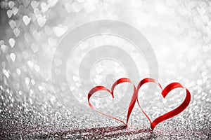 Two ribbon hearts on glowing background
