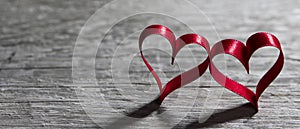 Two ribbon hearts on wood