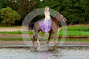 Two riders on horseback at sunset on the beach. Lovers ride horseback. Young beautiful man and woman with a horse at the sea. Rom