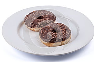 Two ring donuts with chololate glaze on white plate