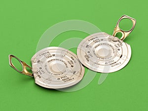 Two ring-pull metal lids on green