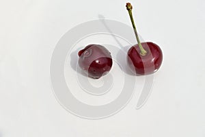 Two ripe cherries on a white background close-up