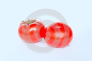 Two ripe fresh red tomatoes isolated on light background