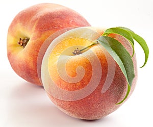 Two ripe peach with leaves