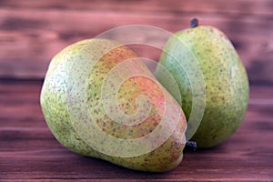 Two ripe pears on an old wooden table.