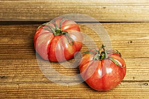 Two ripe pink tomatoes on some unvarnished