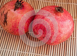 Two ripe pomegranates on a texture background